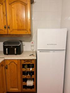 a kitchen with a white refrigerator and some wine bottles at Jennys Bar in Mullagh