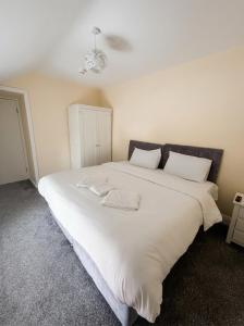 a large white bed with two white pillows on it at Jennys Bar in Mullagh