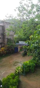 a garden with a building and trees and bushes at ChangGhor in Digru