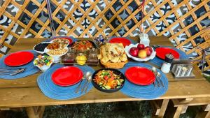 a table with red plates and food on it at BooGoo yurt camp in Song-Kul