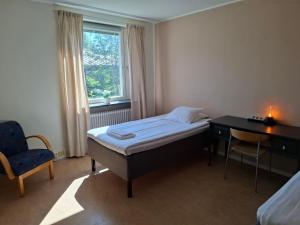 a bedroom with a bed and a desk and a window at STF Luleå Gammelstad Hostel in Nederluleå