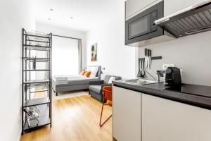 a kitchen with a counter top and a living room at Global Living Chemnitz Rosenhof in Chemnitz