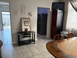 a living room with a table and a refrigerator at Great Choice BnB in Goodwood