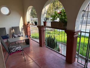 a room with a balcony with arches and a table and chairs at Great Choice BnB in Goodwood