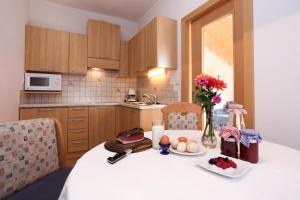 a kitchen with a table with food and flowers on it at Malsethhof in Villandro