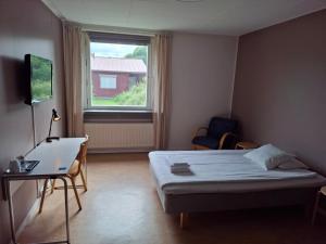 a bedroom with a bed and a desk and a window at STF Luleå Gammelstad Hostel in Nederluleå