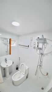 a white bathroom with a toilet and a sink at VelaaOlhu - Turtle Hive Thulusdhoo in Thulusdhoo +49 photos