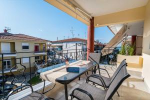 a patio with a table and chairs on a balcony at Kreka Apartments in Pefkochori