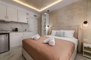 a bedroom with a bed with towels on it at Kreka Apartments in Pefkochori