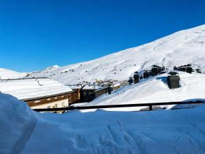 a snow covered mountain with a group of buildings at Hotel Musher in Pas de la Casa