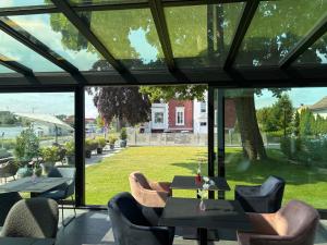 a patio with tables and chairs and a large window at BULVAR boutique in Dziwnów