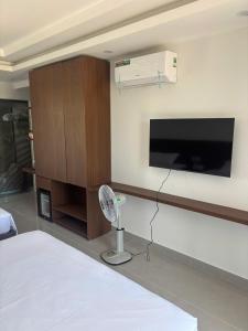 a living room with a flat screen tv and a fan at Thành Danh Hotel in Dong Hoi