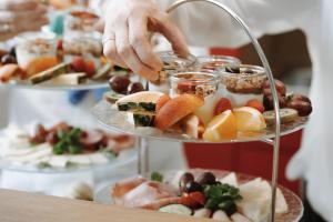 a person serving food on a tiered plate of food at Ferienhaus Alb-Traum in Hayingen