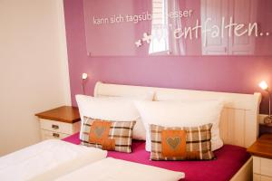 a bedroom with a white bed with two pillows at Ferienhaus Alb-Traum in Hayingen