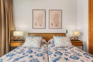 a bedroom with a bed with blue and white sheets and two lamps at Callao Beach 8 in Arrieta