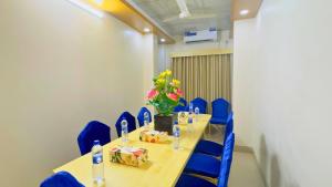 a conference room with a long table and blue chairs at The Ambassador Hotel Dhaka in Dhaka