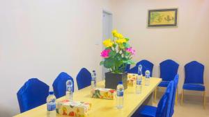 a conference room with a table and blue chairs and flowers at The Ambassador Hotel Dhaka in Dhaka