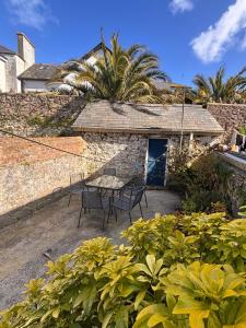 a patio with a table and chairs in front of a building at Central Spacious 3 Bed Cottage, Sleeps 5 in Tenby