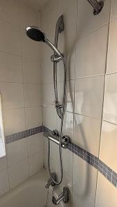 a shower with a shower head in a bathroom at Central Spacious 3 Bed Cottage, Sleeps 5 in Tenby +20 photos