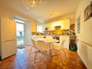 a kitchen with a table and chairs in a room at Central Spacious 3 Bed Cottage, Sleeps 5 in Tenby