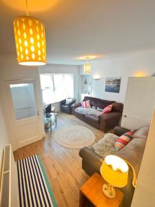 a living room with a couch and a table at Central Spacious 3 Bed Cottage, Sleeps 5 in Tenby