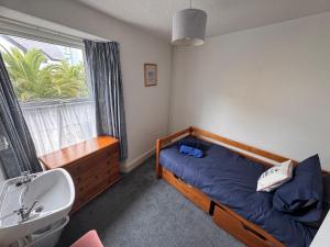 a bedroom with a bed and a sink and a window at Central Spacious 3 Bed Cottage, Sleeps 5 in Tenby