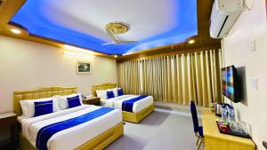 a hotel room with two beds and a tv at The Ambassador Hotel Dhaka in Dhaka +24 photos