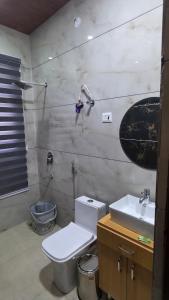 a bathroom with a toilet and a sink at 4j Aravalli Farms in Dhauj +16 photos