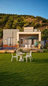 a house with a table and chairs in a yard at 4j Aravalli Farms in Dhauj