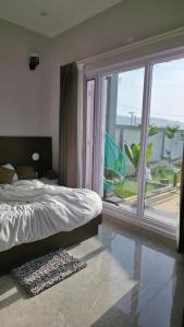a bedroom with a bed and a large window at 4j Aravalli Farms in Dhauj
