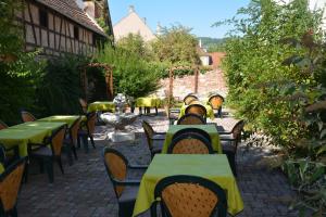 una fila de mesas y sillas en un jardín en Logis Hôtel du Centre - Halte idéale en cyclotourisme avec garage à vélos clos en Molsheim