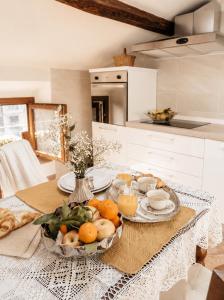 a table with a bowl of fruit on it in a kitchen at Casa Due Marie Boutique stay near Modena & Maranello in Marano sul Panaro