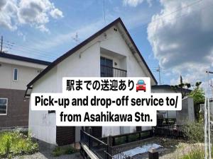 a house with a sign on the side of it at ゲストハウスこだまのおうち in Asahikawa