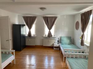 a room with two beds and two windows at Ferienwohnung am Oechsenberg in Unterbreizbach