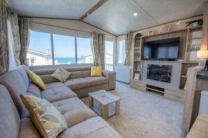 a living room with a couch and a television at Sea View Lodge in Nefyn