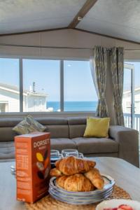 a living room with a couch and a table with a plate of bread at Sea View Lodge in Nefyn