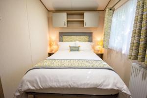 a bed in a small room with a window at Sea View Lodge in Nefyn