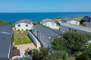 a group of houses with the ocean in the background at Sea View Lodge in Nefyn