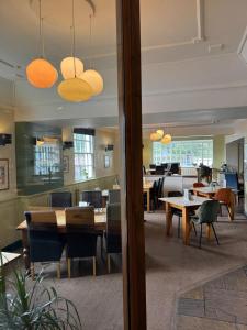 a dining room with wooden tables and chairs at Cheshire Yeoman - Station Hotel in Hooton Station