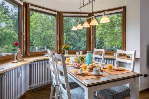 a dining room with a table and chairs and windows at Friedolin im Bärenhüsli in Titisee-Neustadt