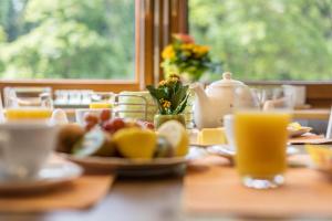 a table with a plate of food and orange juice at Friedolin im Bärenhüsli in Titisee-Neustadt +24 photos