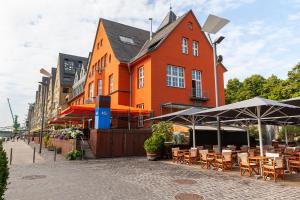 ein orangefarbenes Gebäude mit Tischen und Stühlen davor in der Unterkunft FlatDeCologne - Sommer in der Stadt- City Apartment Nähe DOM in Köln