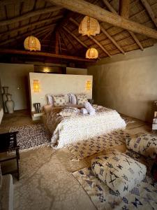 a bedroom with a bed with pillows on it at Agafay Oryx Camp in Aït Mazou