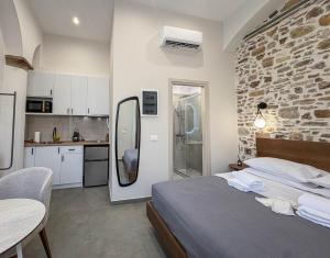 a bedroom with a large bed and a kitchen at Ralli 34 ROOMS&APTS in Chios