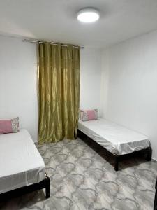 a room with two beds and a curtain at MG Zarzis 2 in Zarzis