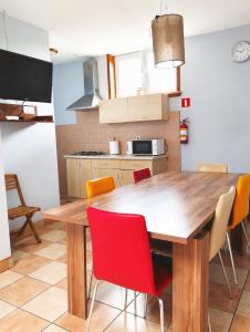 a kitchen with a wooden table and red chairs at Pokoje gościnne u Antka in Krynki
