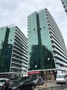 two tall buildings with cars parked in a parking lot at Batumi View Luxury in Adliye