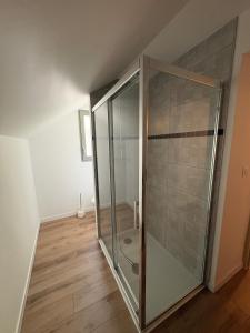 a glass shower in a room with a wooden floor at Maison bord de Loire Logement A in Saint-Rémy-la-Varenne