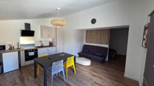 a kitchen and a living room with a table and chairs at Maison bord de Loire Logement A in Saint-Rémy-la-Varenne
