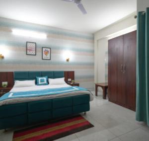 a bedroom with a large bed with a blue headboard at Hotel Riddhinn6 in Jalandhar